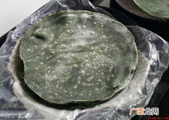 艾草煮熟滤水,切碎或手捏碾一下,擀出又大又圆的薄饼皮 温岭麦饼筒面皮怎么做
